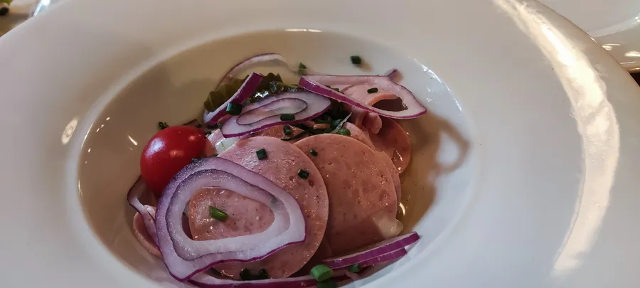 Bayerischer Wurstsalat mit roten Zwiebeln und Essiggurken im Winkelstüberl München