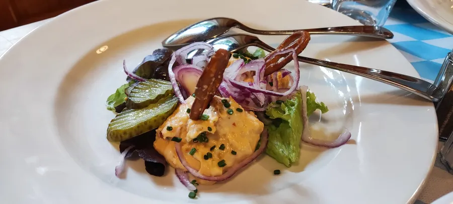 Obatzda mit roten Zwiebeln, Essiggurken und Brezenstangen im Winkelstüberl