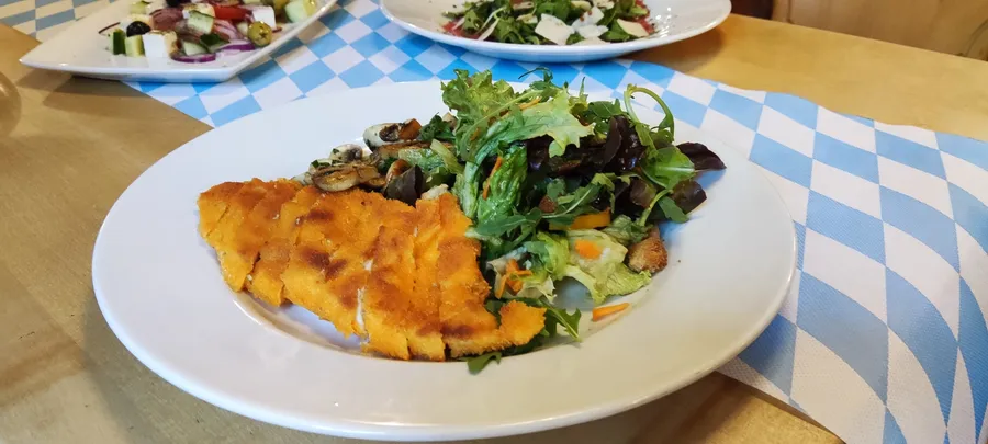 Knusprig paniertes Schnitzel mit gemischtem Salat im Winkelstüberl München