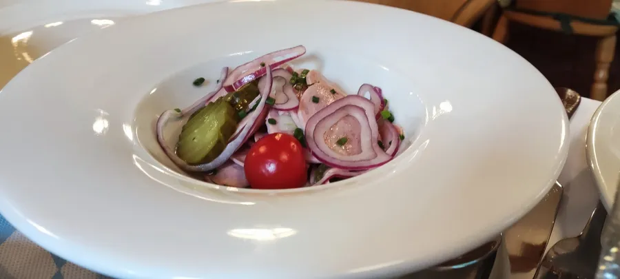 Wurstsalat mit roten Zwiebeln und Essiggurken im Winkelstüberl